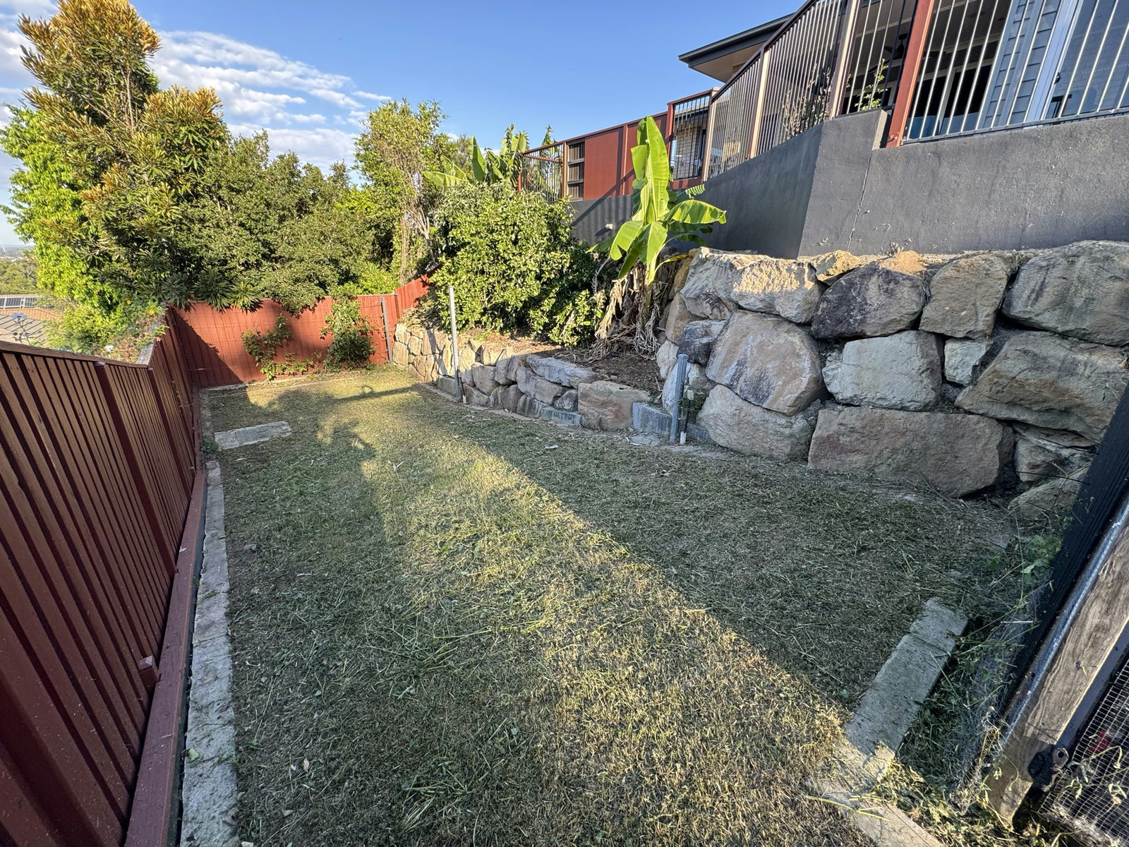 The Holmview lower terrace cleared with the sandstone retaining wall and rockery exposed