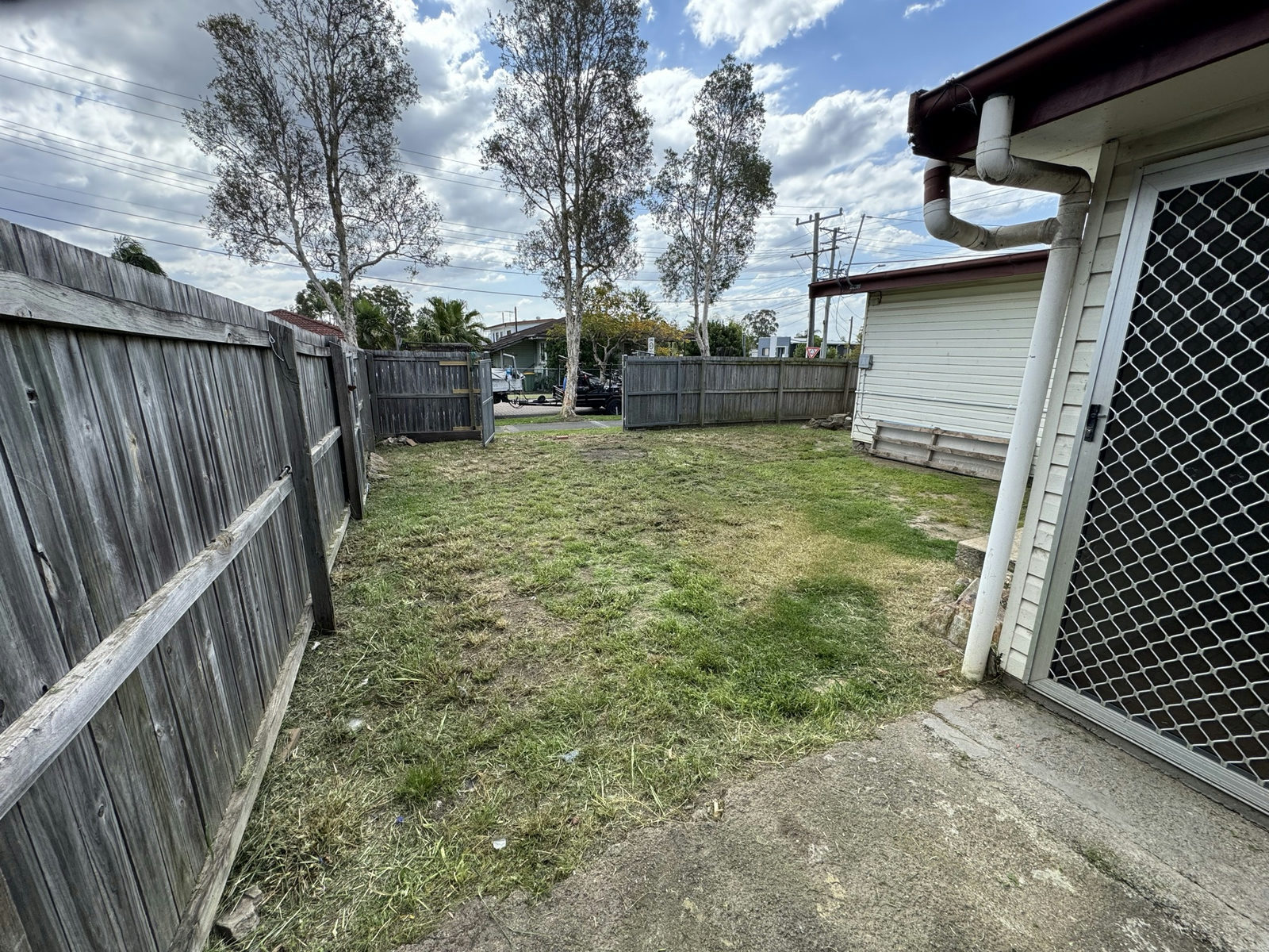 The Logan Central side yard cut back and cleared to the fence line
