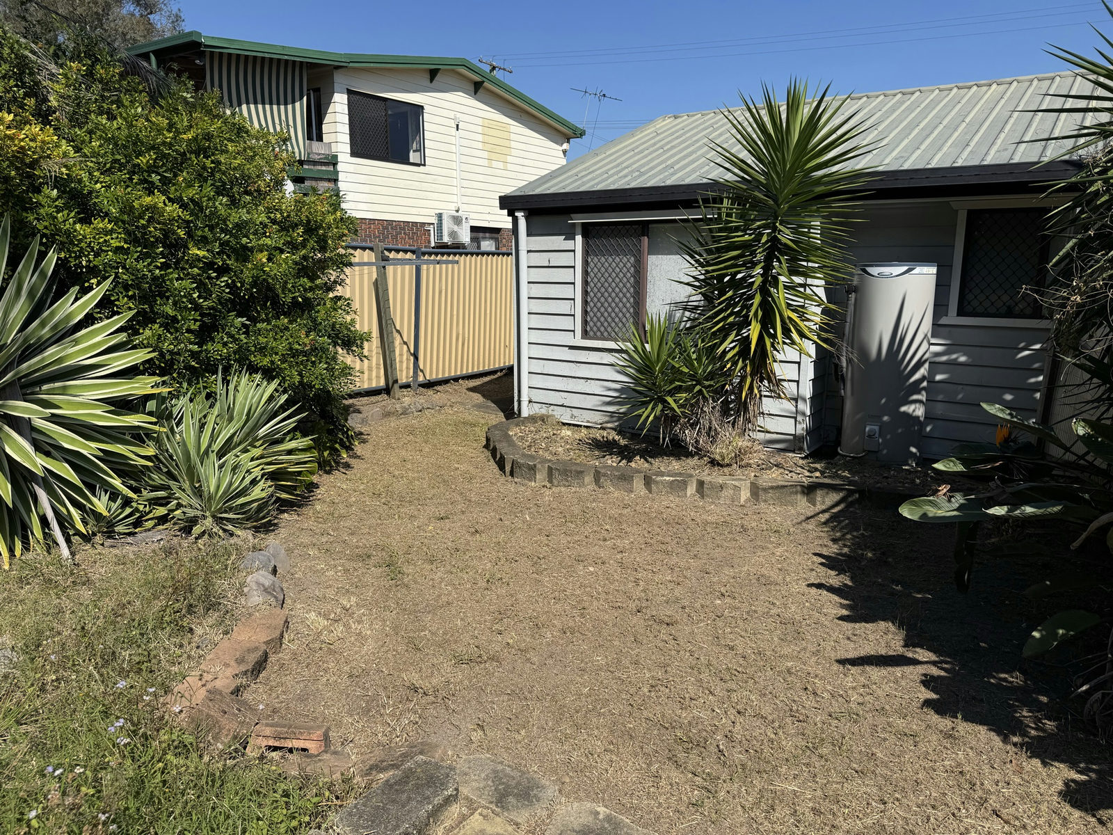 The Marsden side yard cleared back to bare earth with the established yuccas retained
